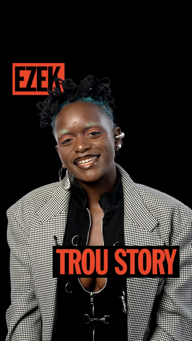 Konbini Trou Story card: Ezek smiling in a houndstooth jacket