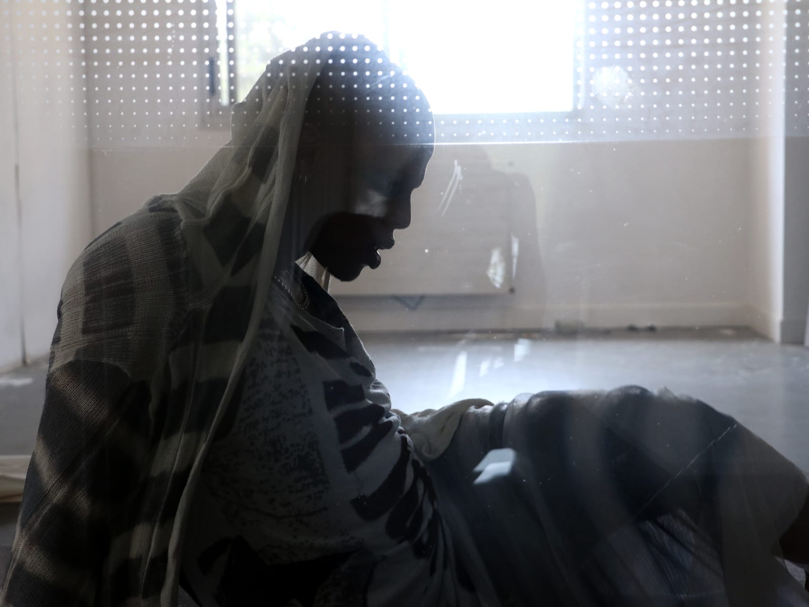 Oluwa veiled in knit against the window light