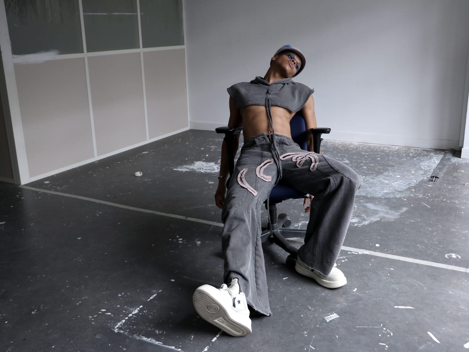 Oluwa leaned back across an office chair, one boot to the floor