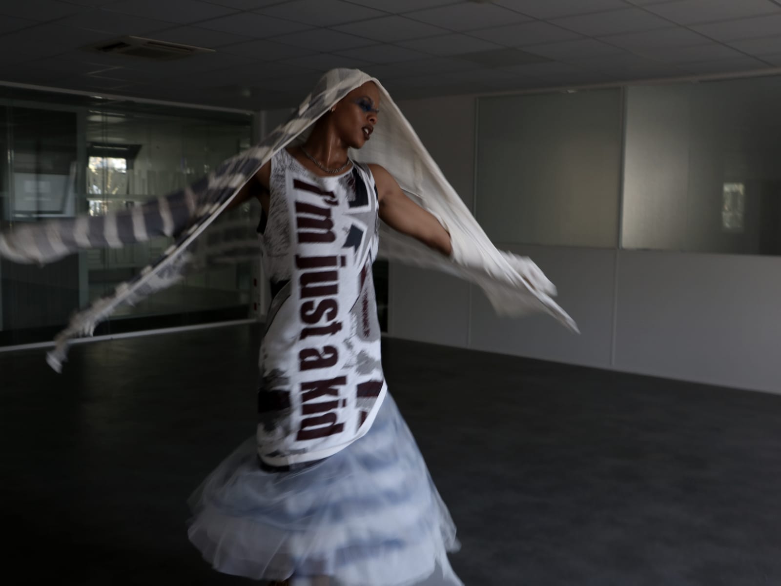 Oluwa mid-spin, shawl ends flying, the tulle skirt turning