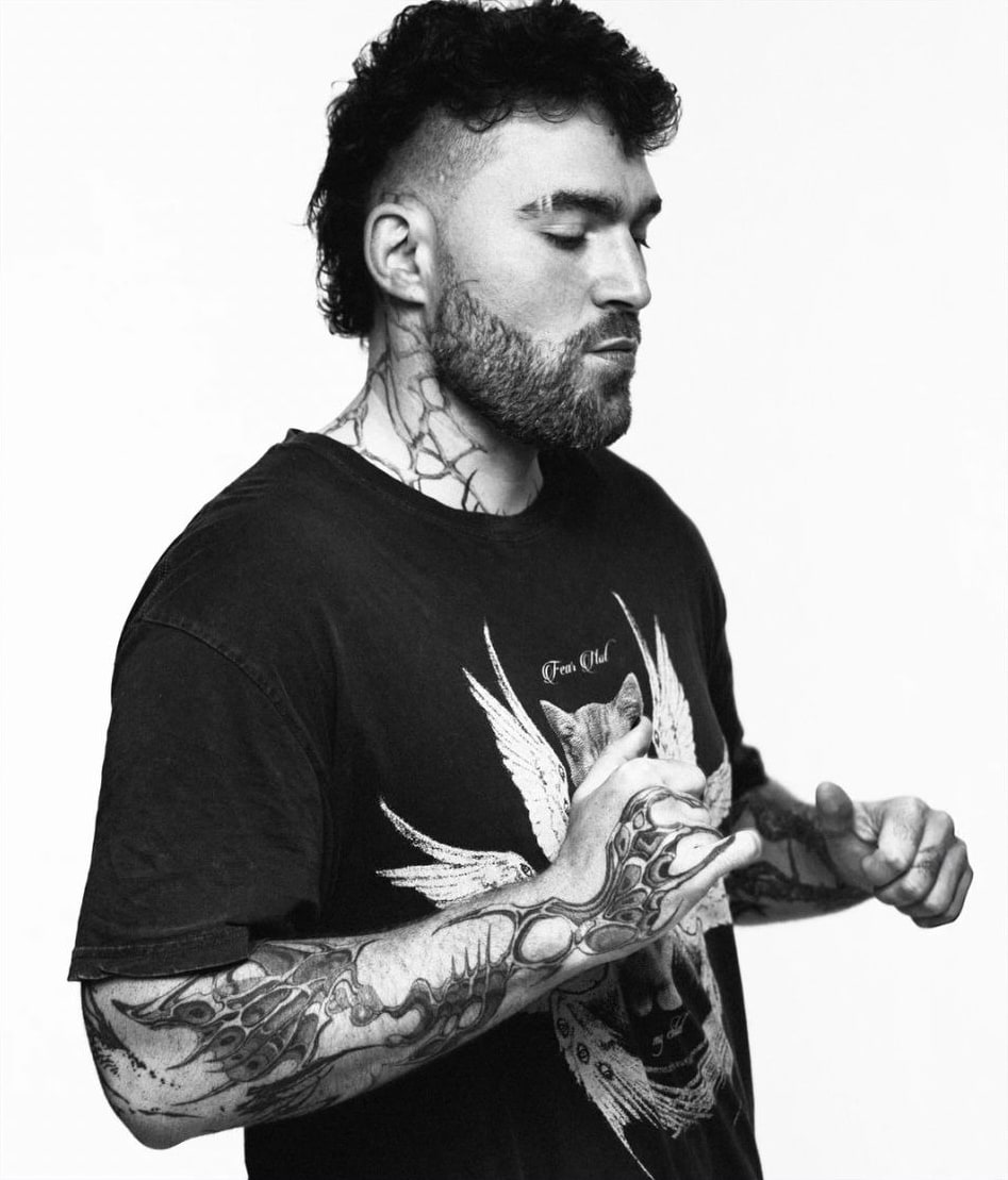 TWONSKi in profile, eyes closed, tattooed hands raised